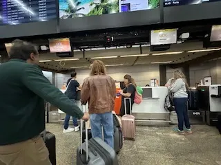 Passageiros no check-in do aeroporto após transfer de van